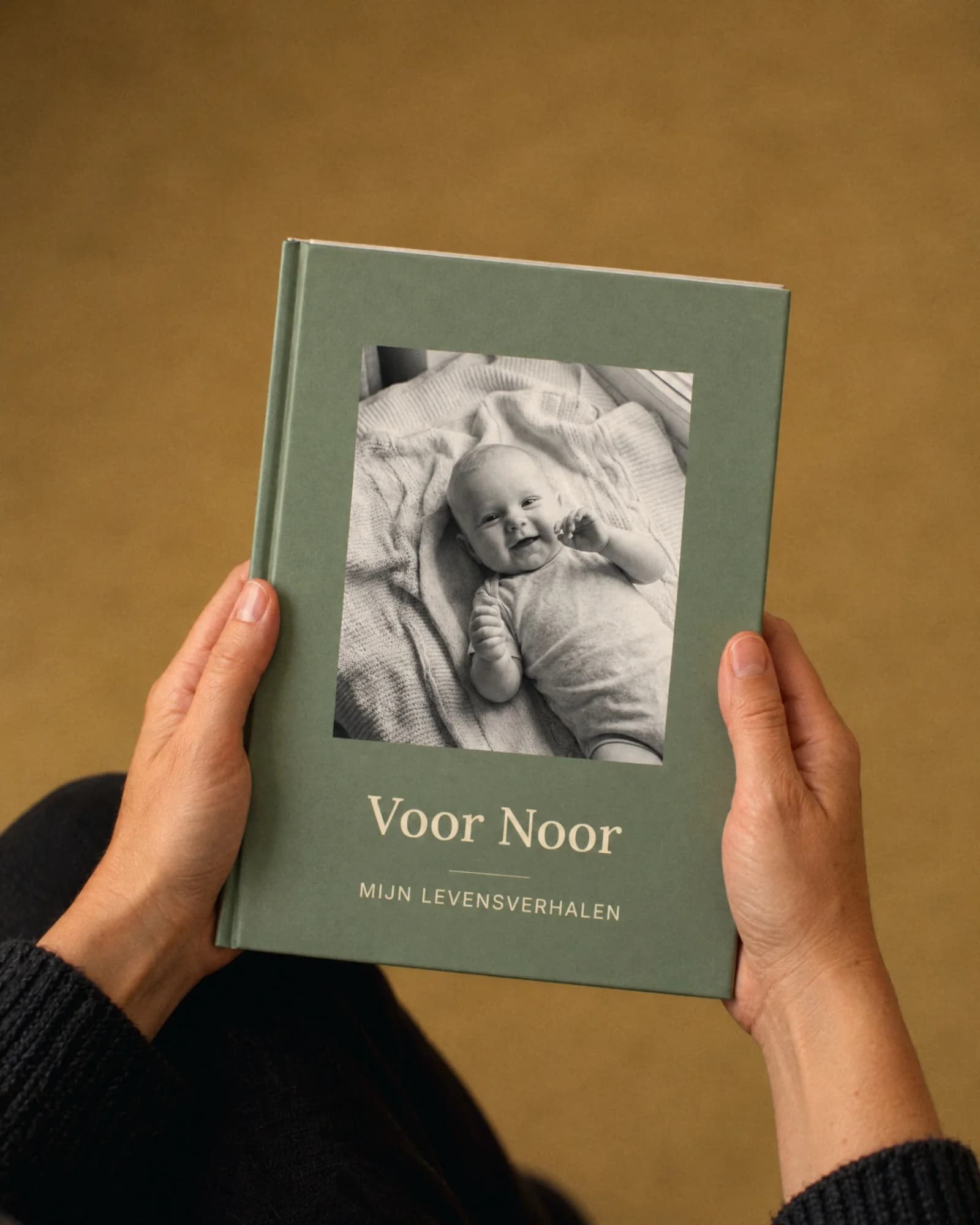 Hände halten das Babybuch Voor Noor.