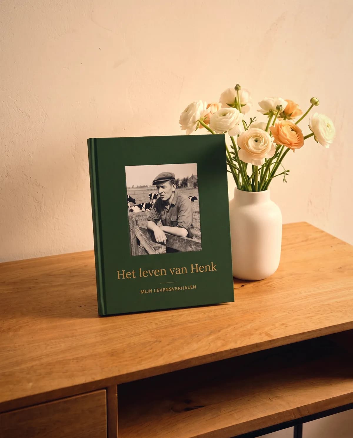 Ein Dein Geschichtenbuch-Buch mit Blumen auf einer Kommode, bereit zum Verschenken an die Eltern.